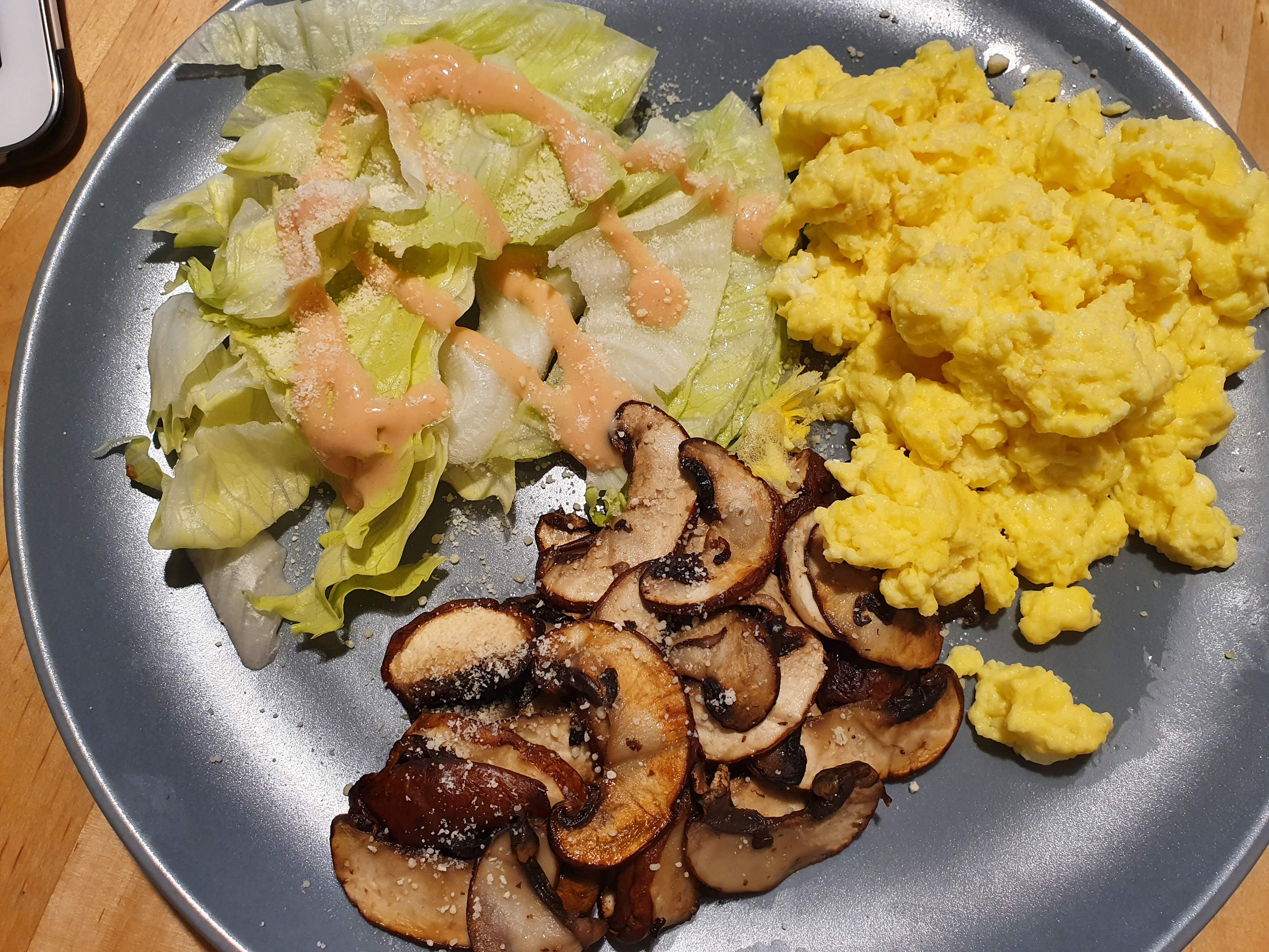 Frühstück aus Rührei, geschmorten Champignons und Salat